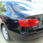 Before and after photographs of a damaged black Volkswagon Jetta that was repaired by Elite Paint & Body Shop in West Palm Beach, Florida.